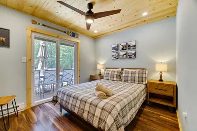 a bedroom with a bed and a ceiling fan at Secluded Cabin, Jacuzzi, Pool Table, King Bed & Fire Pit in Bushkill