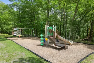 a playground with a slide in a park at Secluded Cabin, Jacuzzi, Pool Table, King Bed & Fire Pit in Bushkill