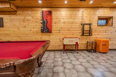 a room with a pool table and a guitar on the wall at Pocono River front Home near Camelback Resort in Barton Glen