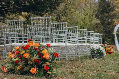 a row of chairs with flowers in the grass at Pocono River front Home near Camelback Resort in Barton Glen