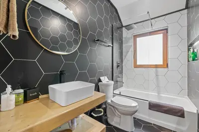 a bathroom with a sink and a toilet and a mirror at Pocono River front Home near Camelback Resort in Barton Glen