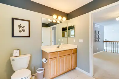 a bathroom with a toilet and a sink and a mirror at Screened Porch and Fire Pit Spacious Pocono Retreat in Pocono Pines