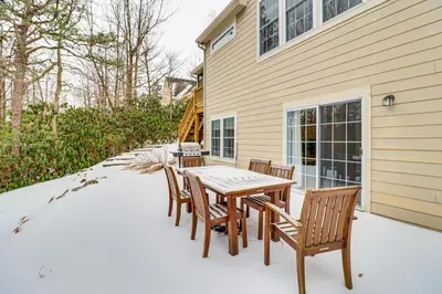 a patio with a table and chairs in front of a house at Screened Porch and Fire Pit Spacious Pocono Retreat in Pocono Pines