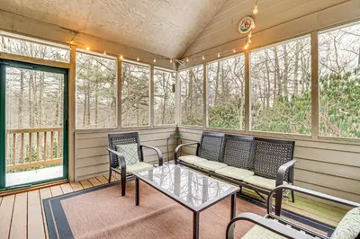 a screened in porch with chairs and a table at Screened Porch and Fire Pit Spacious Pocono Retreat in Pocono Pines
