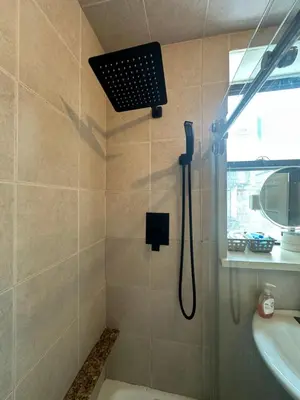 a shower with a shower head and a sink at AL Shami 408 in New York