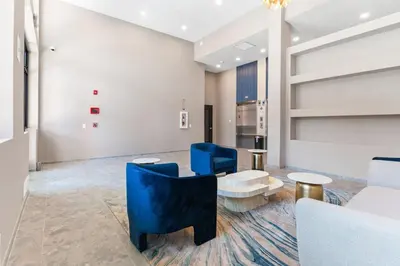 a living room with blue chairs and a couch at 10 mins to CenterCity, With Queen Bed, Views from RT! in Philadelphia