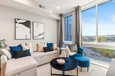 a living room with a couch and a table at 10 mins to CenterCity, With Queen Bed, Views from RT! in Philadelphia