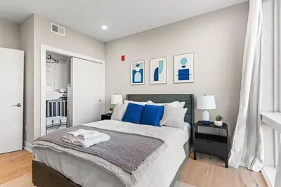 a bedroom with a large bed with blue pillows at 10 mins to CenterCity, Sleeps 6, With Rooftop Views! in Philadelphia