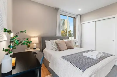 a bedroom with a bed and a desk and a window at 10 mins to CenterCity, Sleeps 6, With Rooftop Views! in Philadelphia