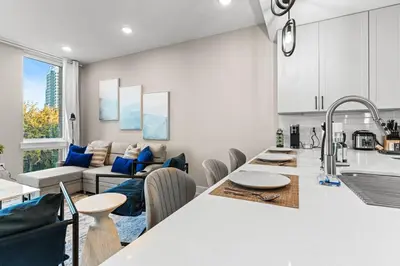 a kitchen and living room with a table and a couch at 10 mins to CenterCity, Sleeps 6, With Rooftop Views! in Philadelphia