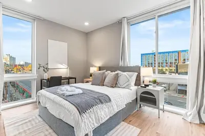 a bedroom with a large bed and large windows at 10 mins to CenterCity, Sleeps 6, With Rooftop Views! in Philadelphia