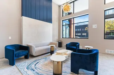 a lobby with blue chairs and a couch and tables at 5 mins to Fillmore! Queen Bed, Rooftop, NorthernLibs! in Philadelphia