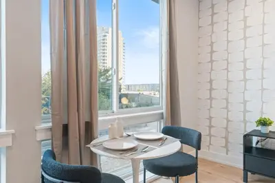 a dining room with a table and chairs and a window at 5 mins to Fillmore! Queen Bed, Rooftop, NorthernLibs! in Philadelphia