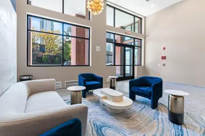 a living room with chairs and a couch and tables at 5 mins to FishTown plus Old Town King Bed, Sleeps 4! in Philadelphia