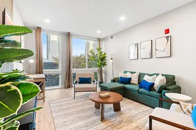 a living room with a green couch and a table at 5 mins to FishTown plus Old Town King Bed, Sleeps 4! in Philadelphia