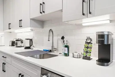 a white kitchen with a sink and a counter top at 5 mins to FishTown plus Old Town King Bed, Sleeps 4! in Philadelphia