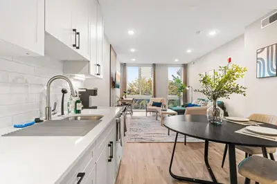a kitchen with a table and a living room at 5 mins to Convention Center! Sleeps 4! With Rooftop! in Philadelphia