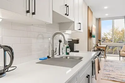 a white kitchen with a sink and a window at 5 mins to Convention Center! Sleeps 4! With Rooftop! in Philadelphia