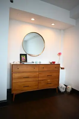 a dresser with a large mirror on a wall at Stunning NYC Views! Free Gym! Doorman! Terrace! in New York