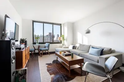 a living room with a couch and a table at Stunning NYC Views! Free Gym! Doorman! Terrace! in New York