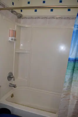 a white bath tub in a bathroom with a shower curtain at Amazing House near EWR and NYC in Linden