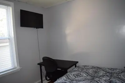 a bedroom with a desk and a bed and a television at Amazing House near EWR and NYC in Linden