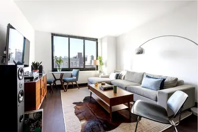 a living room with a couch and a table at Doorman! High Floor! Views! Elevator! Free Gym! in New York