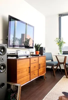 a living room with a tv and a wooden dresser at Doorman! High Floor! Views! Elevator! Free Gym! in New York
