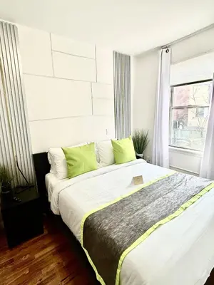 a bedroom with a large bed with green pillows at Apart Studio 12mint From New York City Times Square in West New York