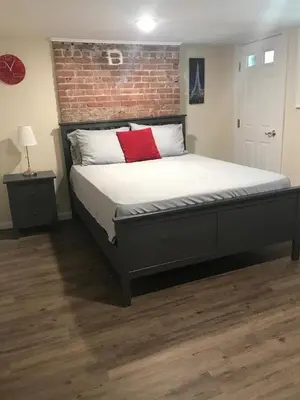 a bedroom with a large bed with a brick wall at Charming Hudson Valley 3-Bedroom Family Getaway in Tomkins Cove