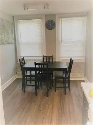 a dining room with a table and chairs and a clock at Charming Hudson Valley 3-Bedroom Family Getaway in Tomkins Cove