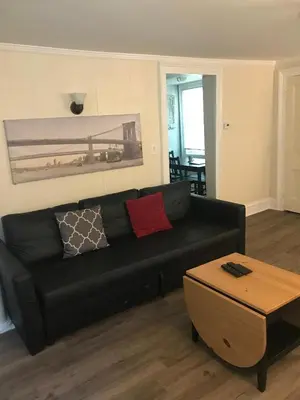 a black couch in a living room with a table at Charming Hudson Valley 3-Bedroom Family Getaway in Tomkins Cove