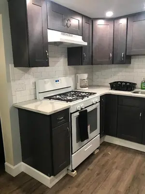 a kitchen with black cabinets and a stove top oven at Charming Hudson Valley 3-Bedroom Family Getaway in Tomkins Cove