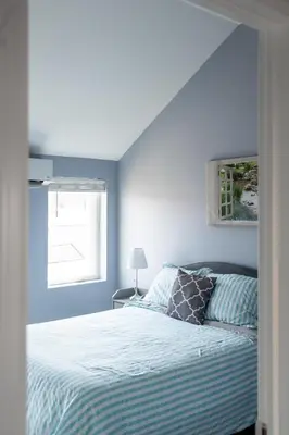 a bedroom with a bed with blue walls and a window at Walk to WP Gate and Free Parking in Highland Falls
