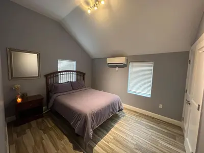 a bedroom with a bed and two windows at Walk to WP Gate and Free Parking in Highland Falls