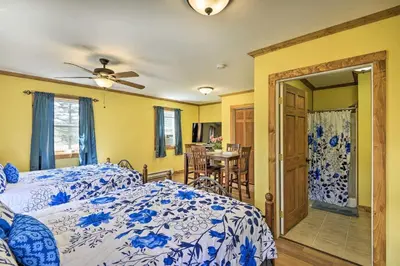 a bedroom with a blue and white bed and a dining room at 2BR Premium Duplex Close to Ski Slopes in Pleasant Mount