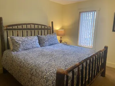 a bedroom with a bed with a wooden headboard and a window at Waterfront Mountain Fun-Jack Frost Walk On Whole House in Blakeslee