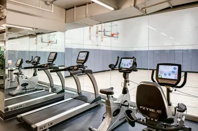 a gym with several tread machines in a row at Blueground Midtown S gym AC nr Empire St NYC-1591 in New York