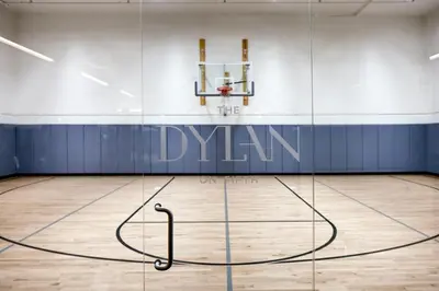 an empty gym with a basketball hoop in the middle of a basketball court at Blueground Midtown S gym AC nr Empire St NYC-1591 in New York