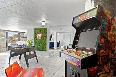 a room with a video game console and a table at Comfort, Fun, & Charming - 5BR Oasis with Pool in Coatesville