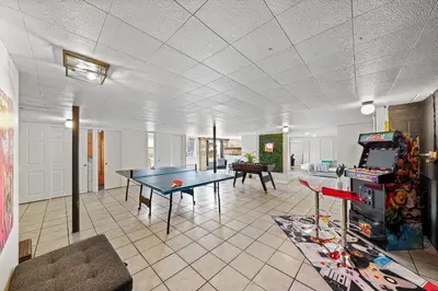 a room with a ping pong table and a video game at Comfort, Fun, & Charming - 5BR Oasis with Pool in Coatesville