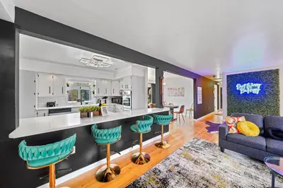 an open kitchen and living room with a blue couch at Comfort, Fun, & Charming - 5BR Oasis with Pool in Coatesville