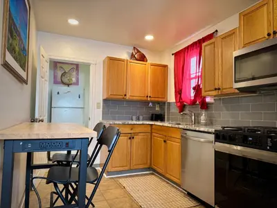 a kitchen with wooden cabinets and a table with chairs at Providence & 18th in Chester