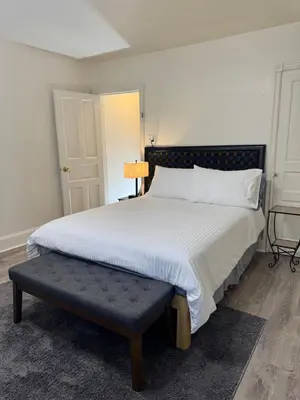 a bedroom with a large white bed with a bench at Providence & 18th in Chester