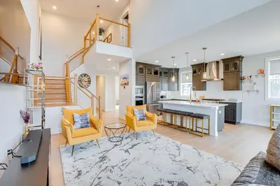 a kitchen and living room with yellow chairs and a staircase at 10 Mi to Morristown Stylish Home Near Trails! in Denville