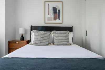 a bedroom with a white bed with a black headboard at UWS 1BR w WD nr Lincoln Center NYC-1187 in New York
