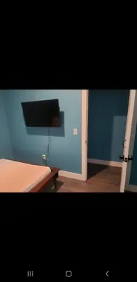 a blue room with a bed and a television at Tasteful 3bedroom Vacation home in Newark