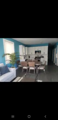 a living room with a table and chairs and a kitchen at Tasteful 3bedroom Vacation home in Newark