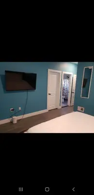 a room with blue walls and a room with a tv at Tasteful 3bedroom Vacation home in Newark
