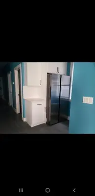 a kitchen with white cabinets and a stainless steel refrigerator at Tasteful 3bedroom Vacation home in Newark